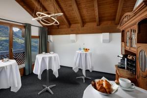 una sala da pranzo con due tavoli e una finestra di Hotel und Naturhaus Bellevue a Seelisberg