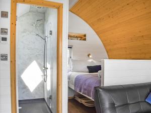 a bedroom with a bed and a glass shower at Seren in Llanddewi Ystradenny
