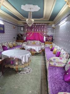 een kamer met paarse bedden en paarse kussens bij Immeuble chakir in Meknès