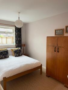 een slaapkamer met een bed, een dressoir en een raam bij St Andrews Golf and holiday home in St Andrews