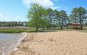 una spiaggia sabbiosa con gazebo e alberi di Gorgeous Home In Spore With Wifi a Spore