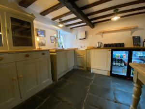 uma cozinha com armários brancos e um frigorífico em Seatoller House em Borrowdale Valley