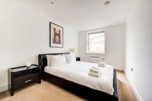 a white bedroom with a bed and a window at GuestReady - Uma escapadela encantadora em Highbury in London