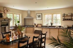 a kitchen with a wooden table and a dining room at Luxury Interior Designed 4 Bedroom Villa, Kenmare in Kenmare