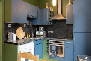 a kitchen with blue cabinets and a refrigerator at GuestReady - Comfortable stay in Manchester in Manchester