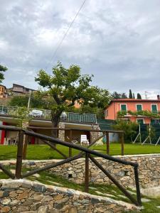 einen Holzzaun mit einem Baum auf einem Feld in der Unterkunft Ligo in Villanova dʼAlbenga