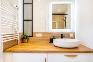 クリシーにあるGuestReady - Paris Delight near the metro stationの白い洗面台と鏡のあるバスルーム