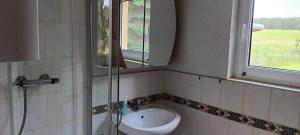 un bagno con un lavandino, uno specchio e una finestra di Zur Schmiede a Hasselförde