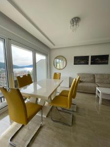 a dining room with a white table and yellow chairs at Deluxe Apartment 2-rooms in Herceg-Novi +6 photos