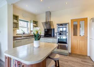 a kitchen with a counter with a vase of flowers on it at Haystax Holiday Lodges in Knitsley