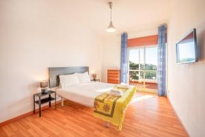 Un dormitorio con una cama grande y una ventana. en GuestReady - Charming stay with a terrace, en Carcavelos