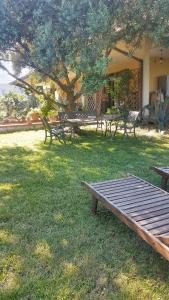 a picnic table and benches in a yard with a tree at 2 bedrooms apartement with lake view enclosed garden and wifi at San Mauro Pascoli 3 km away from the beach in San Mauro Pascoli