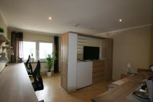 a living room with a television and a room with a dining room at Haus Pleidelsheim in Pleidelsheim