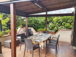 a patio with a table and chairs under a pergola at 2 bedrooms apartement with lake view enclosed garden and wifi at San Mauro Pascoli 3 km away from the beach in San Mauro Pascoli