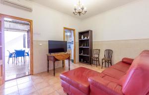ein Wohnzimmer mit einem roten Sofa und einem TV in der Unterkunft 3 Bedroom Cozy Home In Santa Pola in Santa Pola