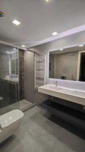 a bathroom with a toilet and a sink and a mirror at GuestReady - Apartamento com vista para o mar e terraço in Barcelona