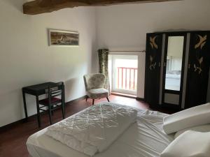 a bedroom with a bed and a desk and a chair at Ferme du Peyronin in Heugas