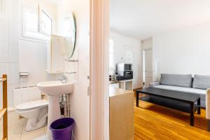 een badkamer met een wastafel en een toilet in een kamer bij GuestReady - Parisian Perch with Eiffel Tower View in Parijs