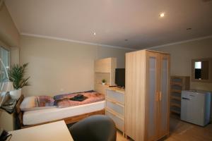 a small bedroom with a bed and a dresser at Haus Pleidelsheim in Pleidelsheim
