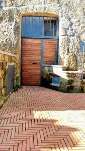 una gran puerta de madera al lado de un edificio de piedra en Studio with city view and wifi at Piansano, en Piansano