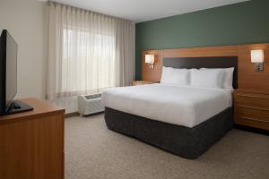 een hotelkamer met een groot bed en een televisie bij TownePlace Suites Richland Columbia Point in Richland