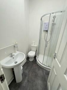a bathroom with a shower and a sink and a toilet at Parkview Residence in Manchester