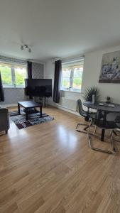 a living room with a table and a television at Spacious 2 bedroom 2 Bathroom Flat in Hatfield near Hertfordshire University with Private Car Park Sleeps 5-6 in Hatfield