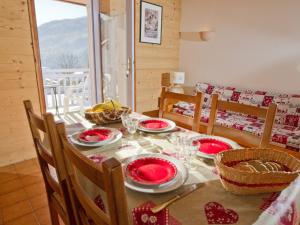 una mesa de comedor con platos rojos. en Appartement Saint-Chaffrey , 2 pièces, 4 personnes - FR-1-762-19, en Saint-Chaffrey