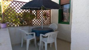 サン・レオナルドにあるStagnone Holiday Homeのテーブル(椅子2脚、傘付)