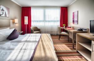 ein Hotelzimmer mit einem Bett und einem Schreibtisch in der Unterkunft Leonardo Hotel Hamburg City Nord in Hamburg