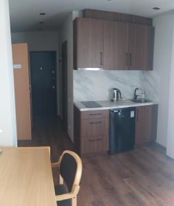 a kitchen with wooden cabinets and a table and a sink at RVR Smart Apartments Riga with Self Check-In in Rīga