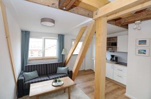 - un salon avec un canapé et une table dans l'établissement Aparthotel an Sankt Marien, à Stralsund