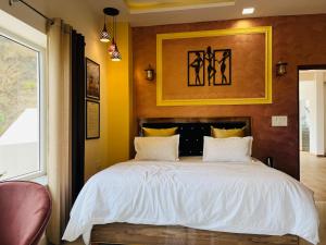 um quarto com uma cama grande e lençóis brancos em Rootz em Dehradun