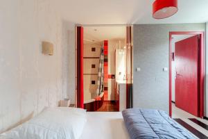 - une chambre avec un lit blanc et une porte rouge dans l'établissement La Cornaline 1, à Cabourg
