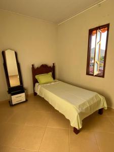- une chambre avec un lit et un miroir dans l'établissement Casa Freire Mafra, à Rio de Contas