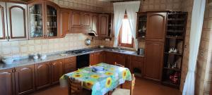 uma cozinha com armários de madeira e uma mesa com uma toalha de mesa em Panoramico WiFi TV Centro Storico em Casteldaccia