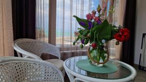 uma mesa de vidro com um vaso de flores em Villa Flora em Sozopol