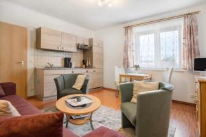 a living room with a couch and chairs and a table at Ilse - Ferienwohnungen Zinnowitz in Zinnowitz