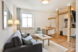 ein Wohnzimmer mit einem Sofa und einem Tisch in der Unterkunft Aparthotel an Sankt Marien in Stralsund