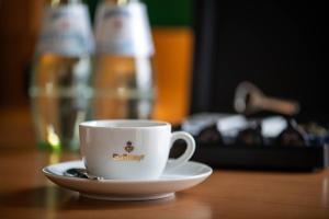 uma chávena de café num pires numa mesa em SleepBEEONE AIRPORTHOTEL FRANKFURT MÖRFELDEN em Mörfelden-Walldorf