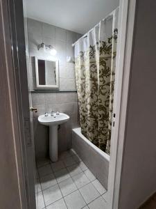een badkamer met een wastafel en een douchegordijn bij Depto25nuevo in Mendoza