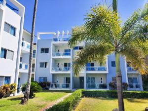 um edifício de apartamentos com palmeiras em frente em Beauty Sol Tropical pool views apartment close to Bavaro Beach em Punta Cana