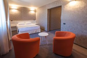 a room with two chairs and a bed and a table at YMY HOTELS Târgu Jiu in Târgu Jiu
