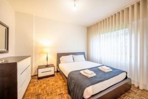 ein Schlafzimmer mit einem Bett mit zwei Handtüchern darauf in der Unterkunft GuestReady - Tranquil retreat in Lisbon in Lissabon
