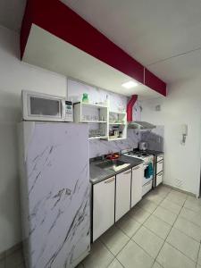 Una pequeña cocina con microondas y nevera. en Depto25nuevo, en Mendoza