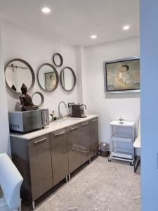 La salle de bains est pourvue d'un lavabo et de miroirs sur le mur. dans l'établissement Palms Luxury Suites Sanremo, à Sanremo