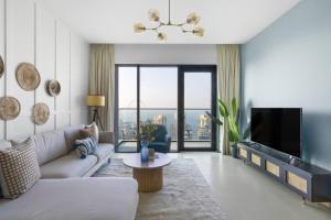 uma sala de estar com um sofá e uma televisão em GuestReady - Vida High-Floor Elegance em Dubai