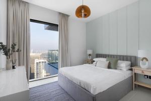 um quarto com uma cama grande e uma janela grande em GuestReady - Vida High-Floor Elegance em Dubai