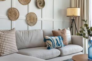 uma sala de estar com um sofá branco com almofadas em GuestReady - Vida High-Floor Elegance em Dubai