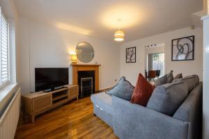 - un salon avec un canapé et une télévision dans l'établissement GuestReady - Charming Retreat near Salford Quays, à Manchester